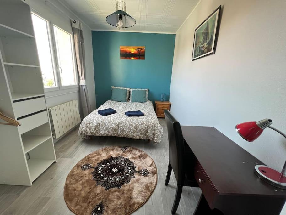 - une chambre avec 2 lits, un bureau et une table dans l'établissement logement entier spacieux/lumineux/parking privé, à Toulouse