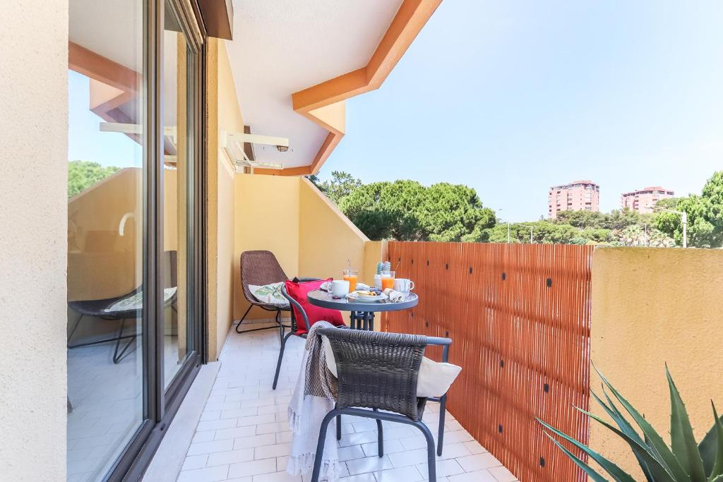 a small patio with a table and chairs on a balcony at Vita Portucale ! Sandset Park View in Costa da Caparica