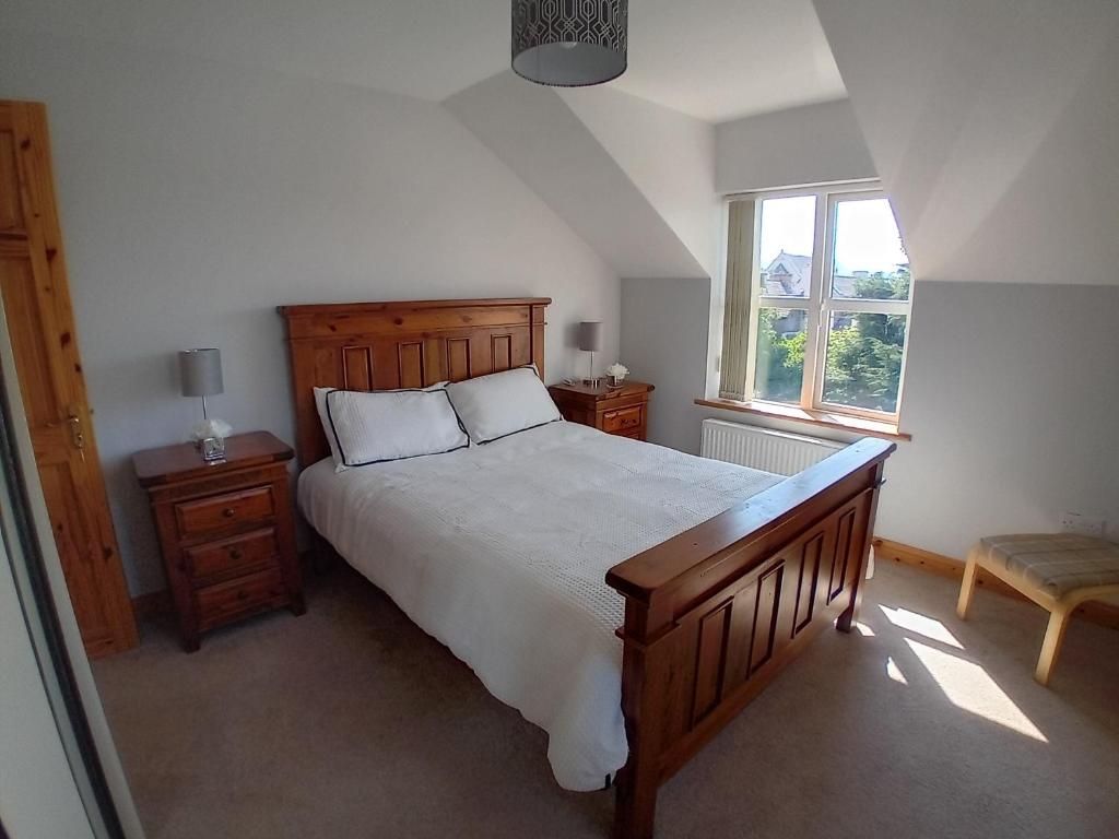 a bedroom with a large bed and a window at The Red Door Townhouse Apartment in Ardara