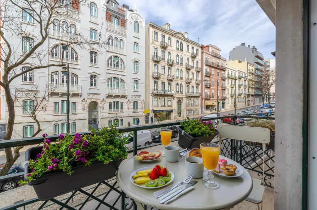 a table with food and drinks on a balcony at LX51 Studios & Suites by APT IIN in Lisbon