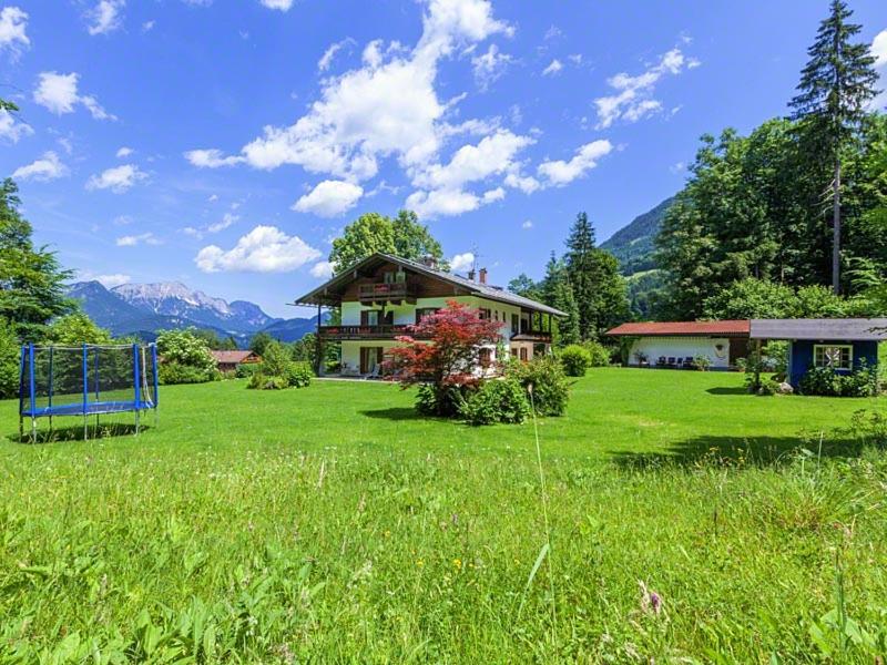 una casa en medio de un campo verde en Ferienwohnung Mankei en Schönau am Königssee