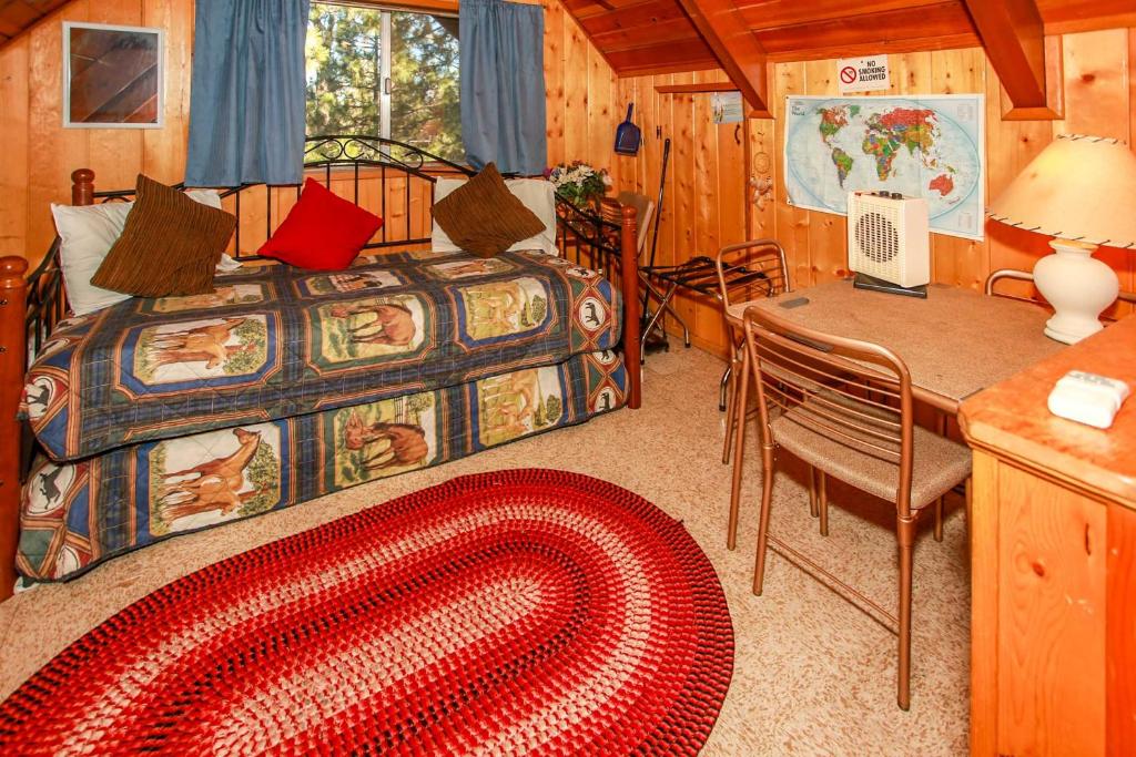 een slaapkamer met een bed, een bureau en een tafel bij Big Bear Cabin 4U - Fenced yard on heavily treed lot, experience a true Big Bear Cabin! in Big Bear Lake