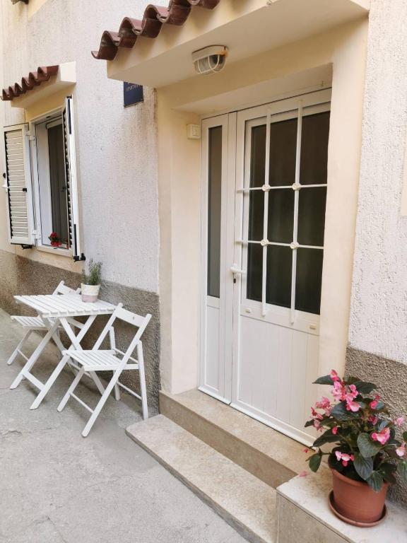 a patio with a table and a chair next to a door at Kovacine apartment in Cres