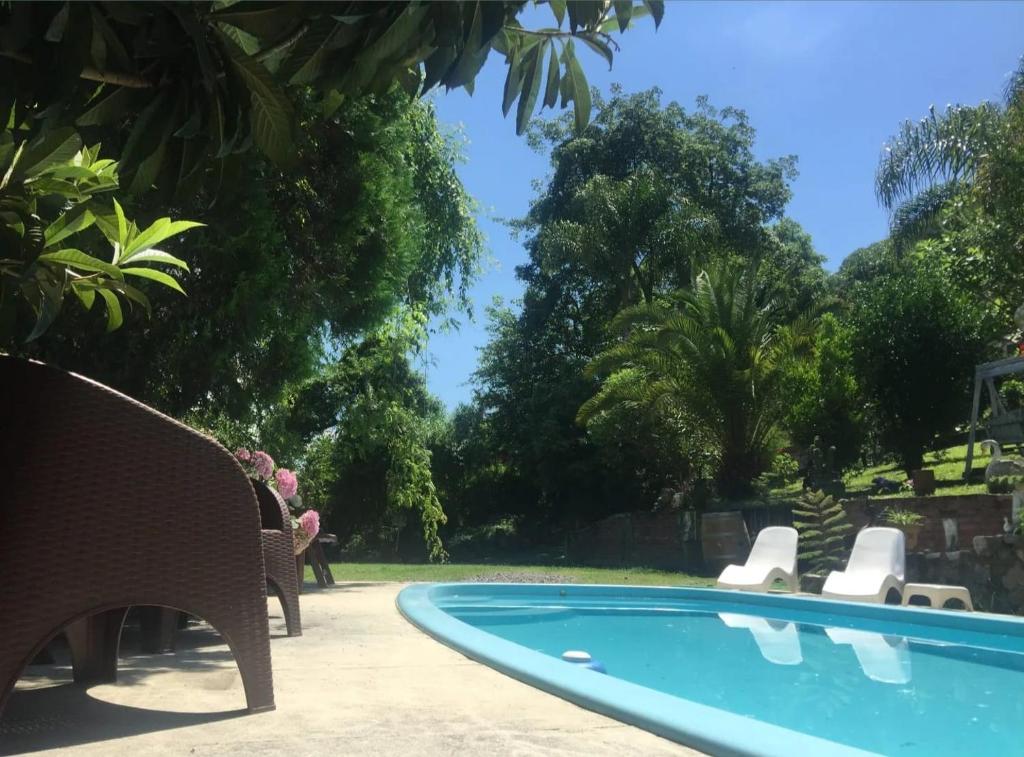 una piscina en un patio con sillas y árboles en Las Watanas en Reyes