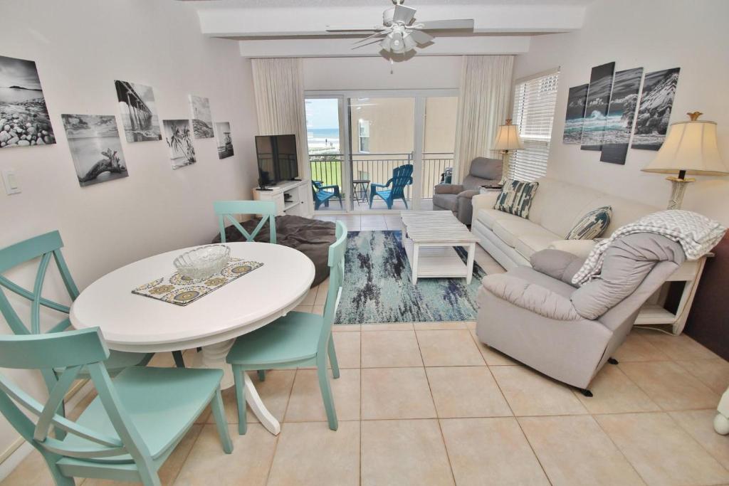 a living room with a table and chairs and a couch at Ocean Club North C208 in New Smyrna Beach
