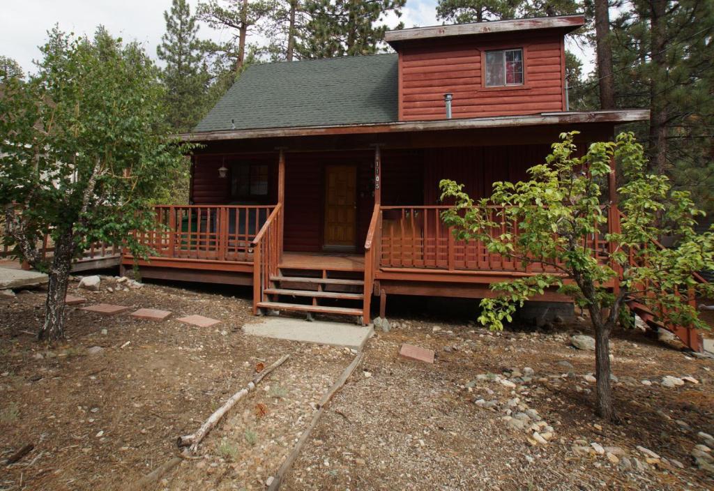 a log cabin with a porch and stairs to a house at Canyon Cabin - A quaint cabin in a peaceful location yet close to Big Bear's attractions! in Fawnskin