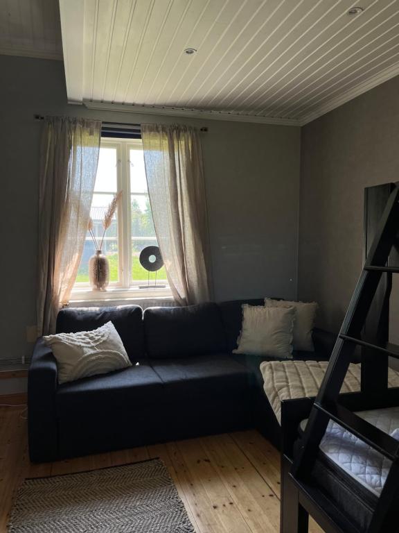 a living room with a blue couch and a window at Stuga i centrala Älvdalen in Älvdalen