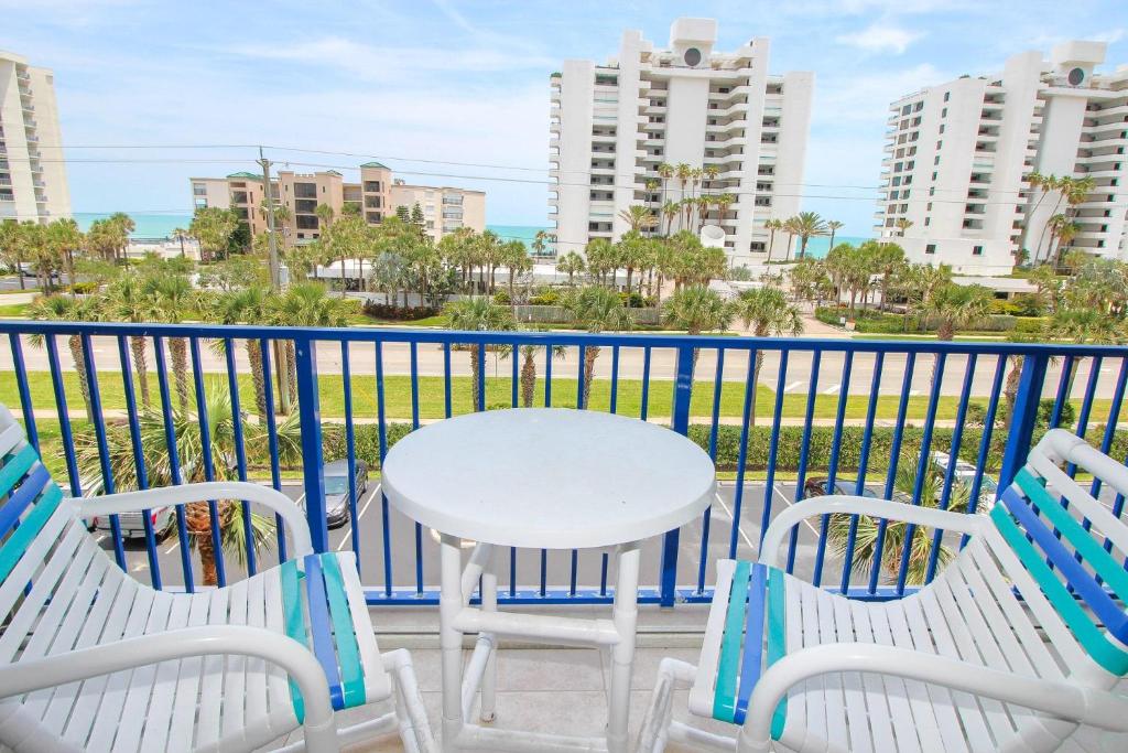 una mesa y sillas en un balcón con vistas al océano en Oceanwalk 12-404, en New Smyrna Beach
