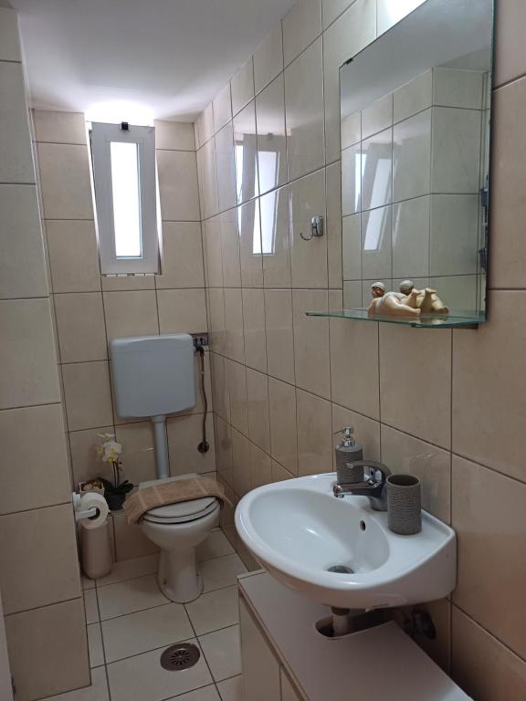 łazienka z umywalką, toaletą i lustrem w obiekcie Maria's Studio No2 in Heraklion w Heraklionie