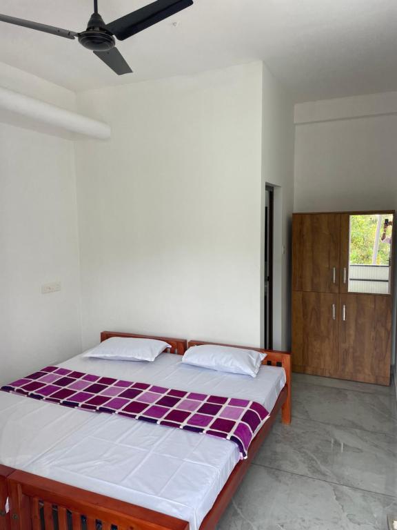 1 dormitorio con 1 cama con sábanas moradas y blancas en New star homes, en Kotamangalam