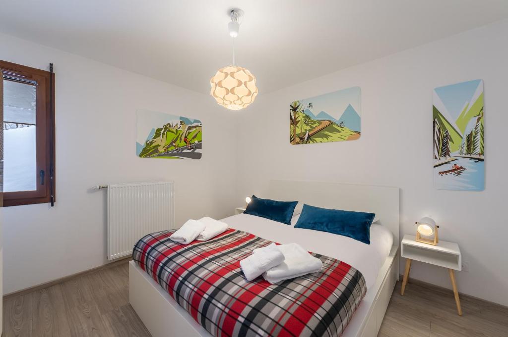 a bedroom with a bed and a pendant light at Les Loges Blanches - Apt B103 - BO Immobilier in Châtel
