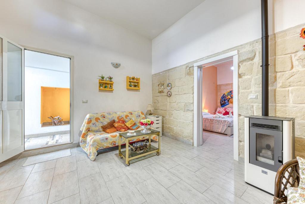 un soggiorno con divano e camino di Casa vacanze vicino a Otranto a Giurdignano