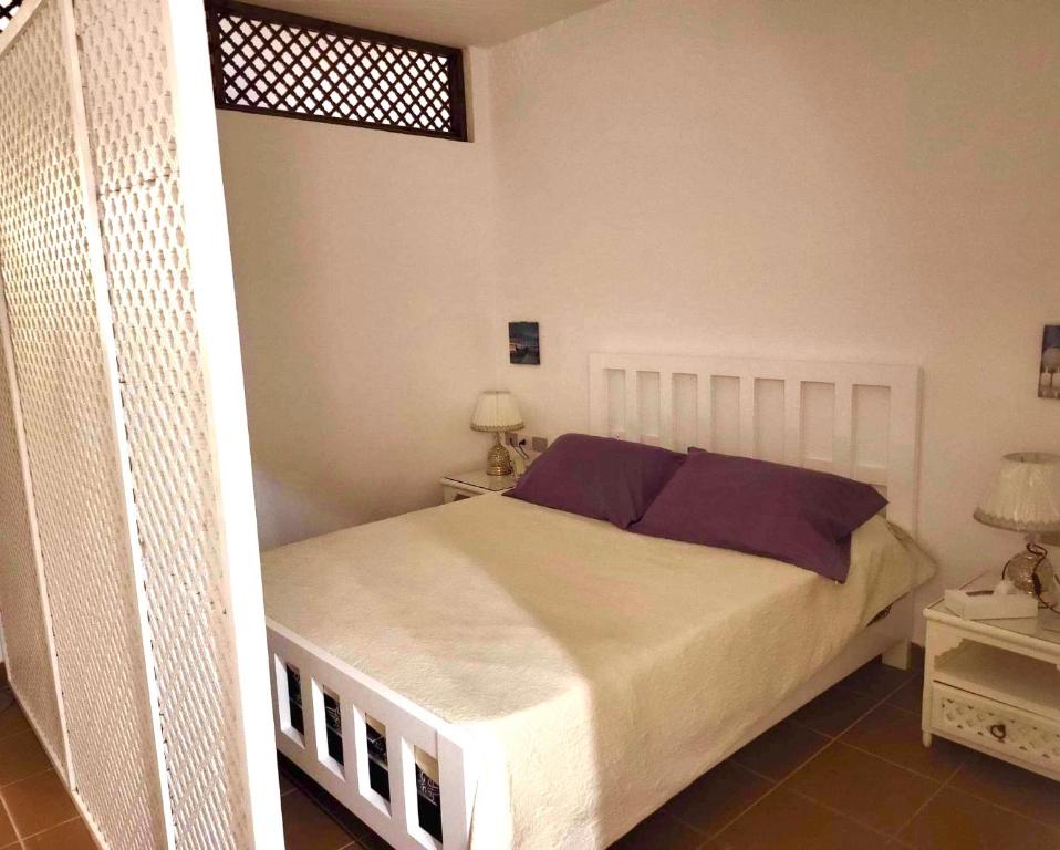 Domina Coral Bay Resort &casino في Dawwār Ruḩayyim: غرفة نوم مع سرير كبير مع وسائد أرجوانية