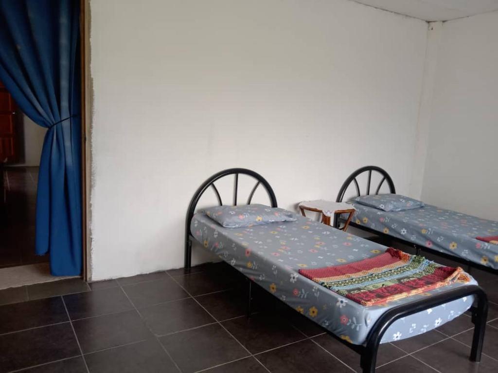 a room with two beds and a mirror at MULU BACKPACKER HOMESTAY in Mulu