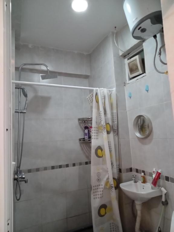 uma casa de banho com uma cortina de chuveiro e um lavatório em RB studio apartment with free Wi-Fi em Dar es Salaam