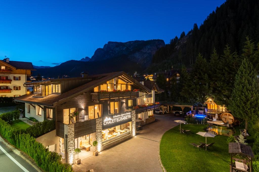 eine Luftansicht eines Hauses mit einem Berg in der Unterkunft Chalet Elisabeth dolomites alpin & charme in Wolkenstein in Gröden