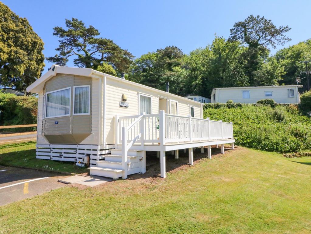a mobile home with a porch and stairs on a yard at Horizon in Combe Martin