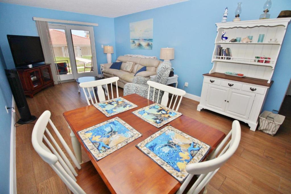 comedor con mesa y sala de estar en Sea Coast Gardens II 117, en New Smyrna Beach