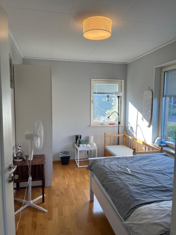 a bedroom with a bed and a fan and a window at A room in a villa close to Arlanda Airport in Stockholm