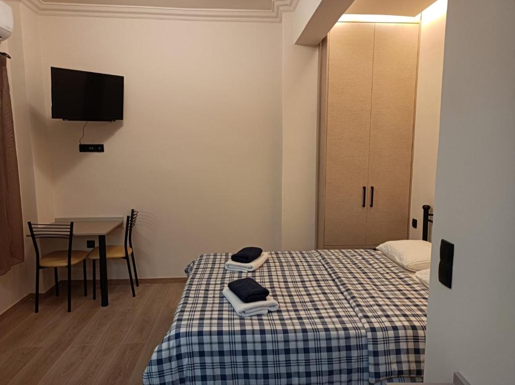a room with two beds and a table and a tv at Apartment Dipla 3 in Athens