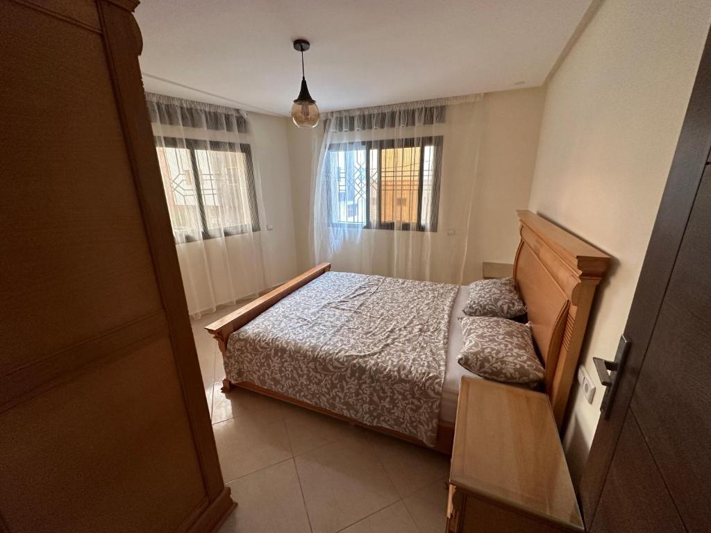 um quarto com uma cama e duas janelas em Residence Akodad em Al Hoceïma