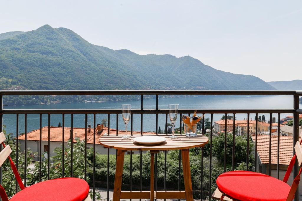 una mesa en un balcón con vistas al agua en La Dolce Vista by My Home In Como, en Moltrasio