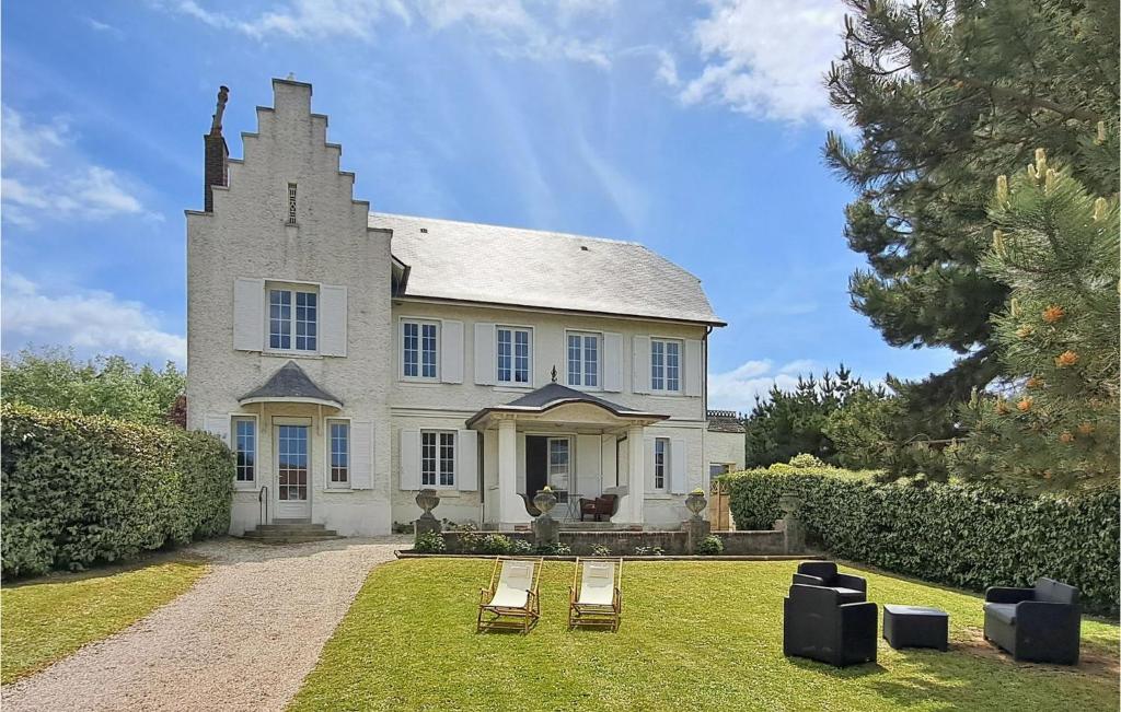 une maison avec deux chaises de jardin devant elle dans l'établissement Awesome Home In Benerville-Sur-Mer, à Benerville-sur-Mer