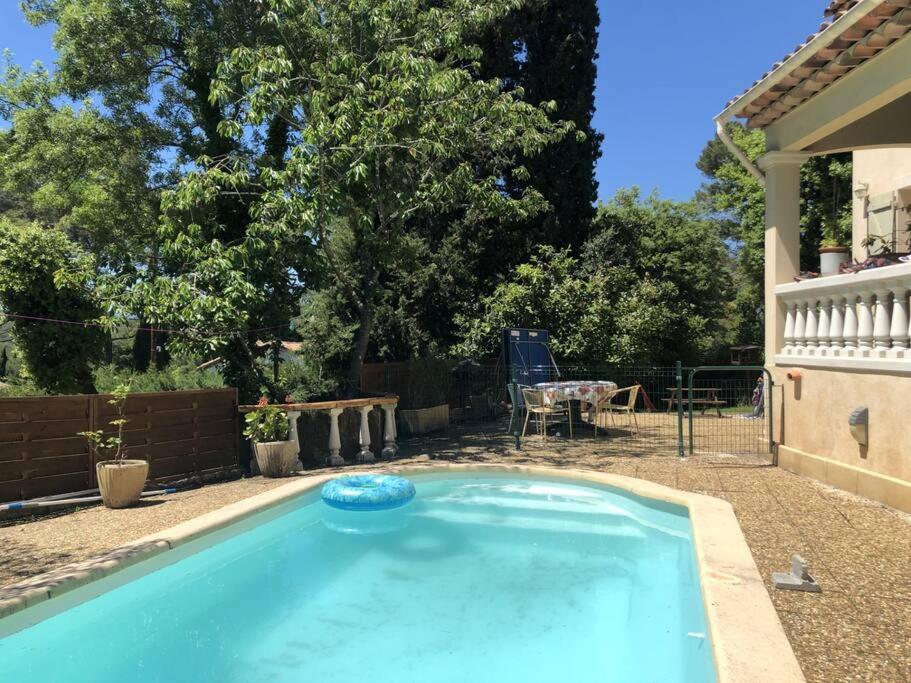 una piscina azul con un frisbee. en Villa spacieuse avec piscine proche de la mer en Biot