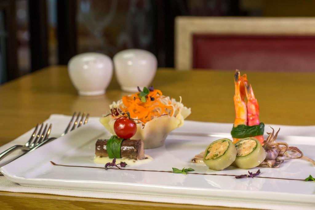 a plate of food on a wooden table at Metropolitan Al Mafraq Hotel in Abu Dhabi