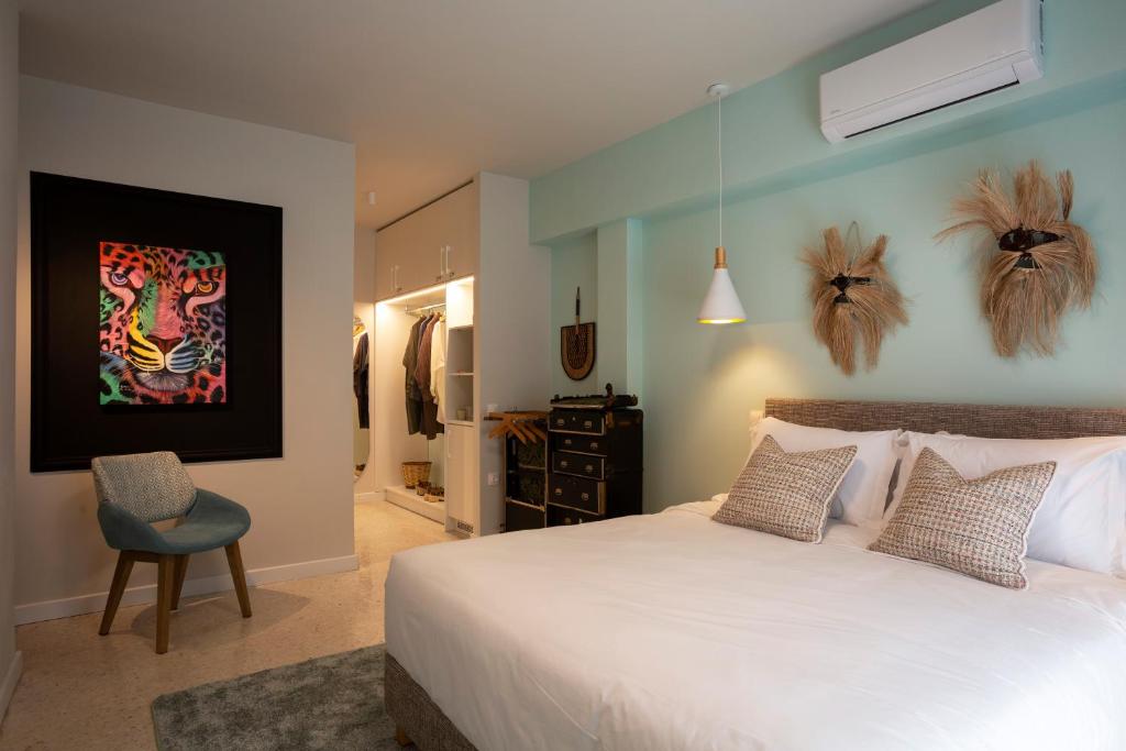 een slaapkamer met een groot wit bed en een stoel bij The Frogs_Guest House in Athene