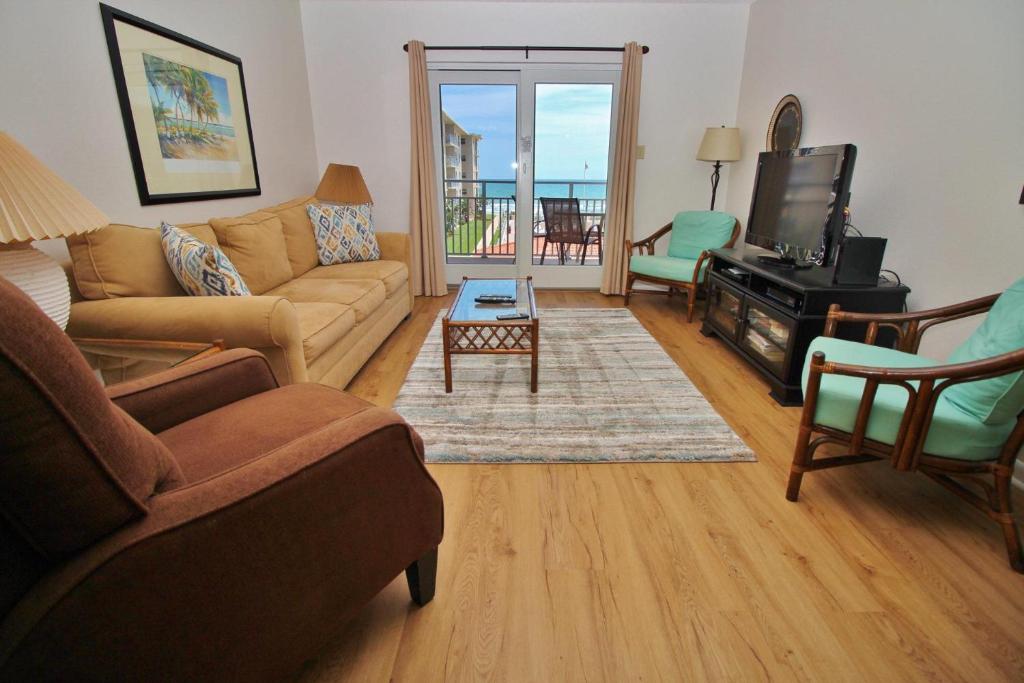 a living room with a couch and a television at Sea Coast Gardens II 317 in New Smyrna Beach