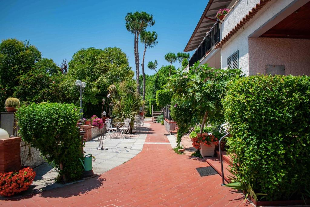 chodnik z czerwonej cegły z roślinami i kwiatami obok budynku w obiekcie Residence Al Lago w mieście Castiglione del Lago