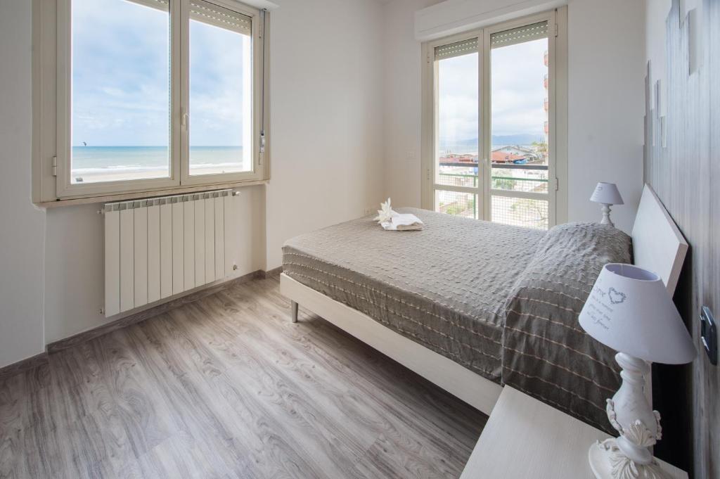 1 dormitorio con 1 cama y vistas al océano en Appartamenti Le Perle di Venere, en Marina di Grosseto