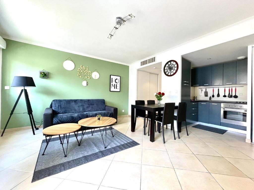 un salon avec un canapé bleu et une table dans l'établissement L'Altezza joli T2, proche plage, terrasse, parking, à Menton