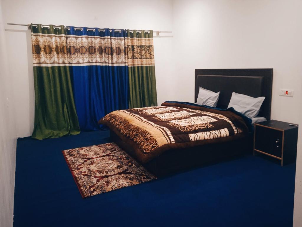 a bedroom with a bed with a blue floor at Nubra Holiday in Deskit