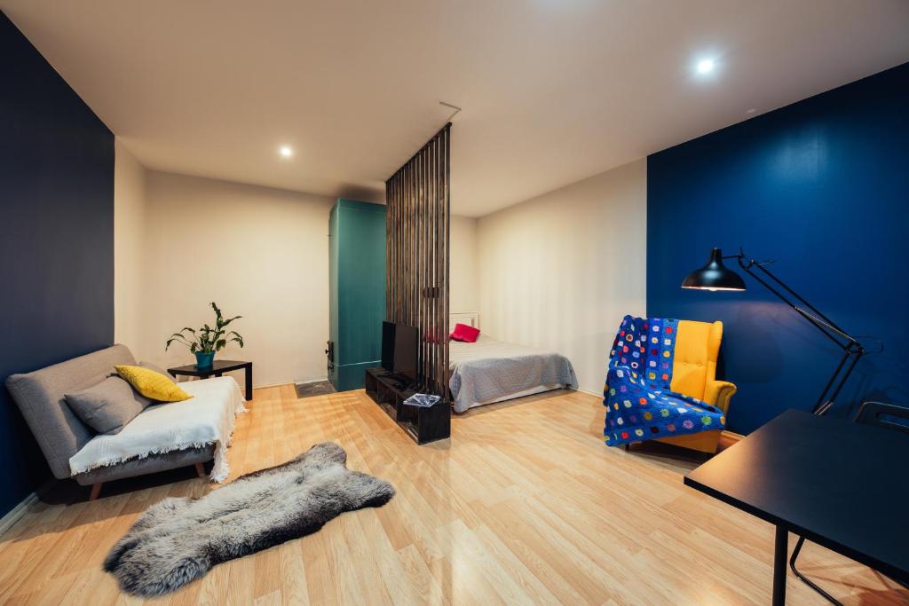 a room with a bed and a couch and a chair at Poorbaltics Studio in Liepāja