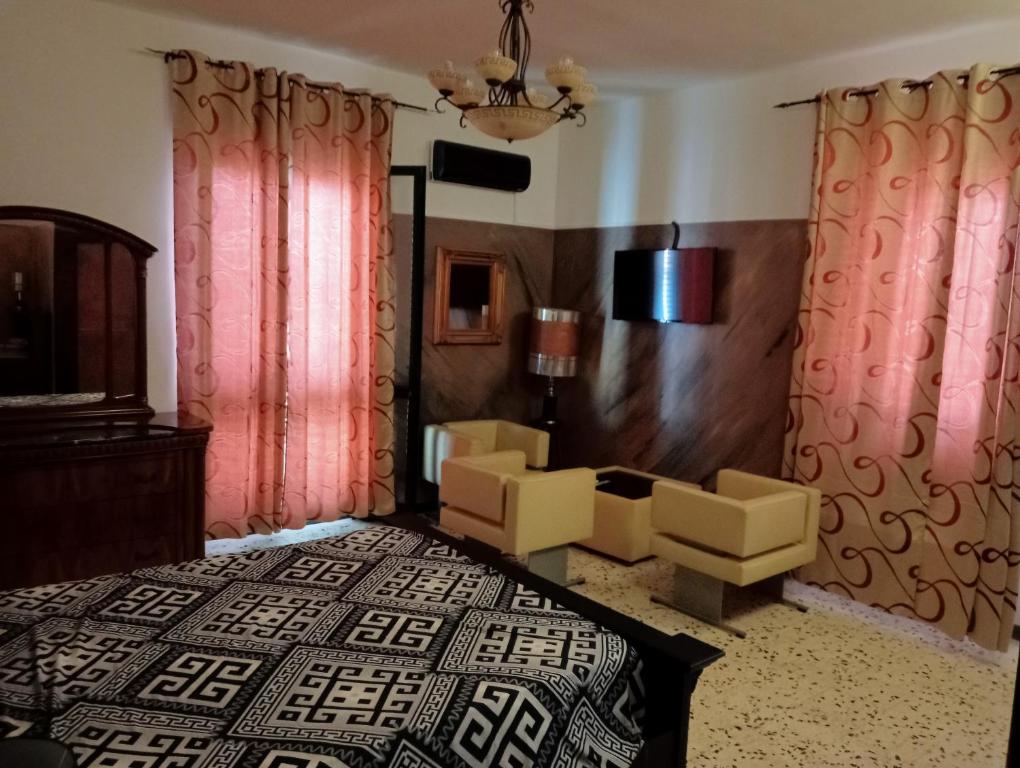 - une chambre avec des rideaux roses, un lit et une chaise dans l'établissement Cala Licina, à Agropoli