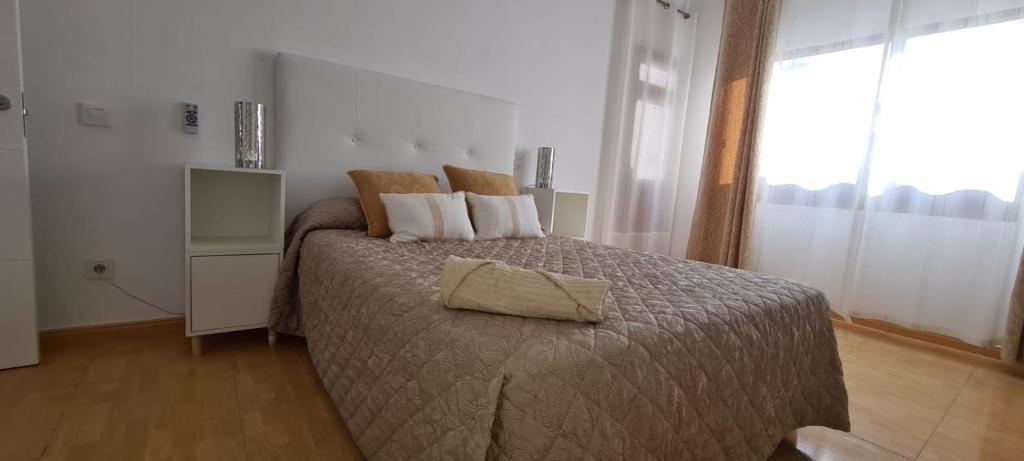 een slaapkamer met een bed met een bruin dekbed bij Piso de 2 habitaciones a 200 metros de la playa in Las Palmas de Gran Canaria
