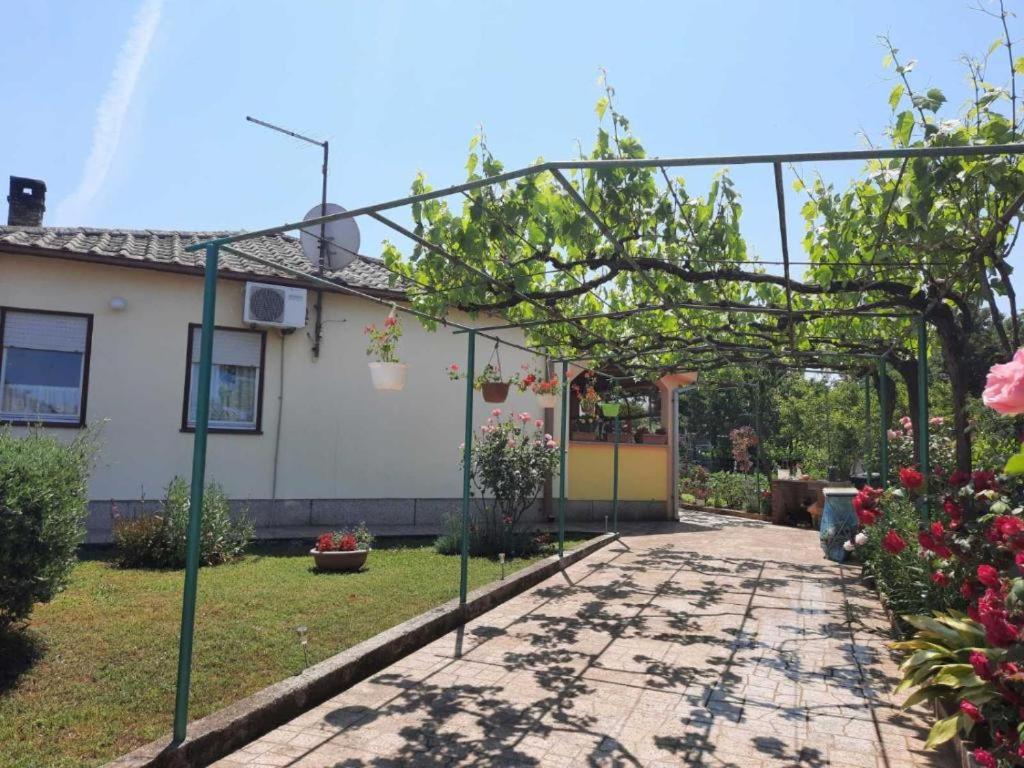 um jardim com uma pérgula em frente a uma casa em Roberto em Fažana