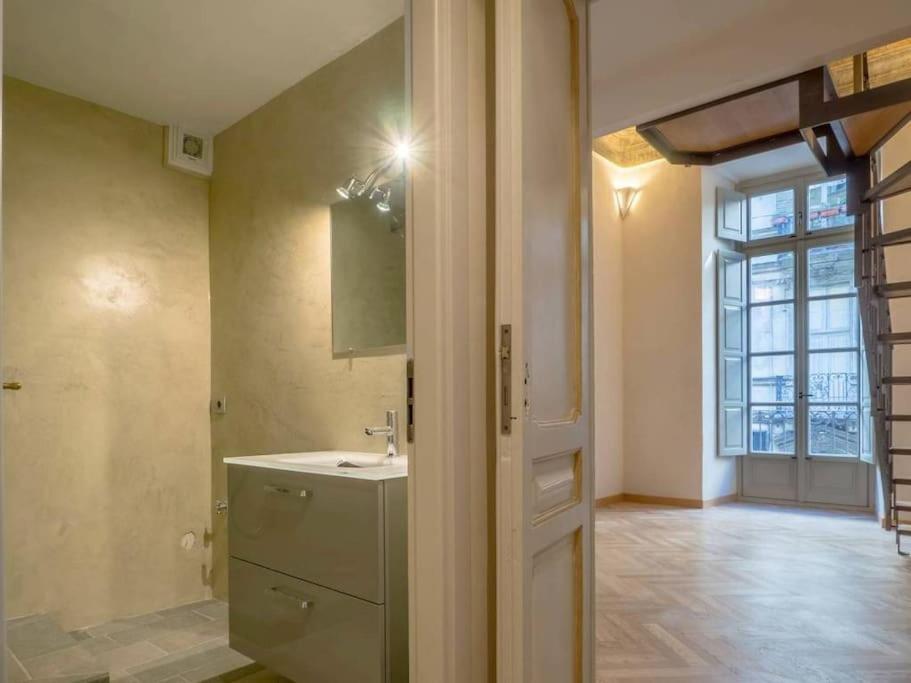 La salle de bains est pourvue d'un lavabo et d'une porte avec fenêtre. dans l'établissement Elegante appartamento in centro., à Turin