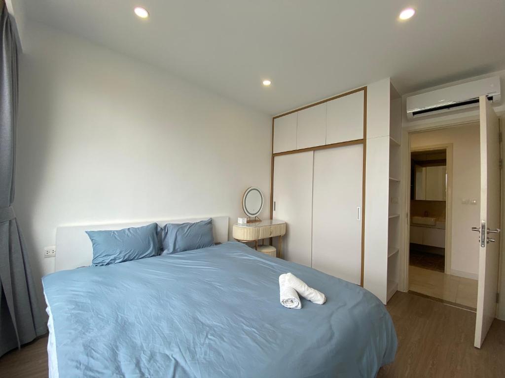 Un dormitorio con una cama azul con una toalla. en Căn hộ dịch vụ theo giờ Dcapitale, en Hanói
