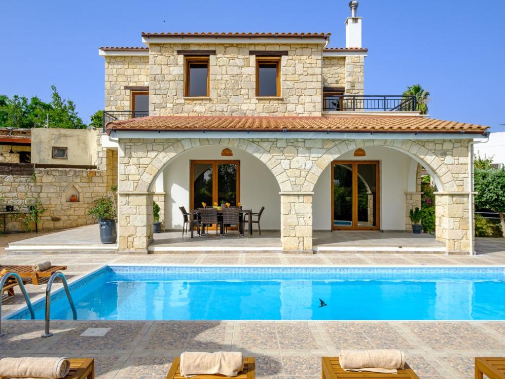 a villa with a swimming pool in front of a house at Almond Grove Luxury Villa Wprivate Pool in Simou