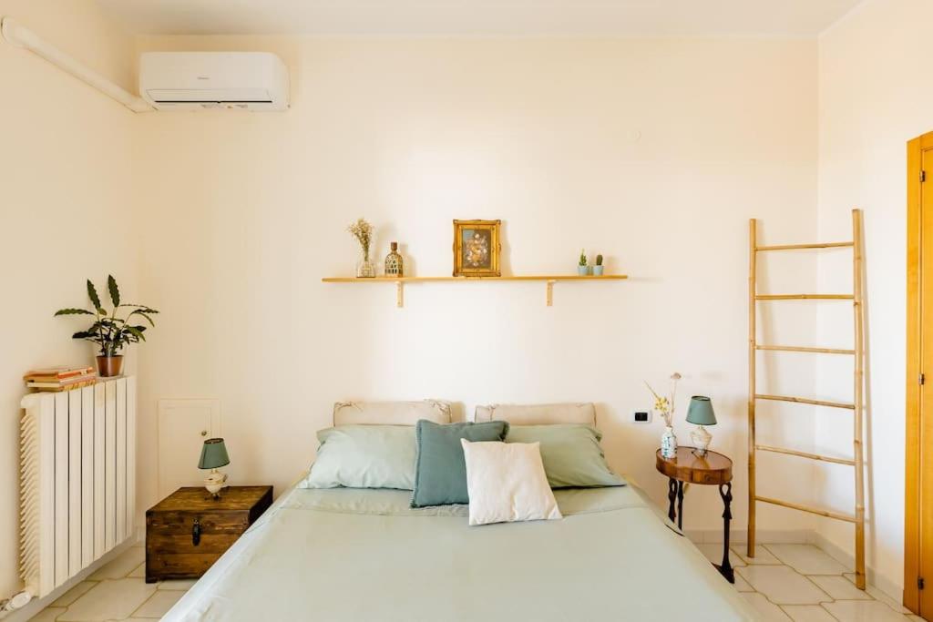 a bedroom with a bed and shelves on the wall at Villa La Serenata di Pietro in Taranto