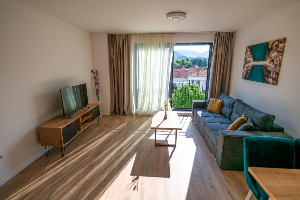 un soggiorno con divano blu e TV di MM Residence Mostar a Mostar