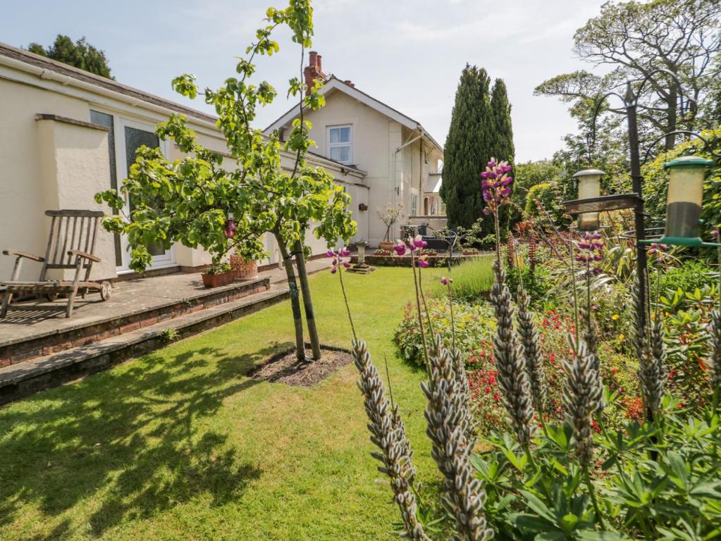 a garden with trees and flowers in a yard at Bryn Offa cottage in Holywell