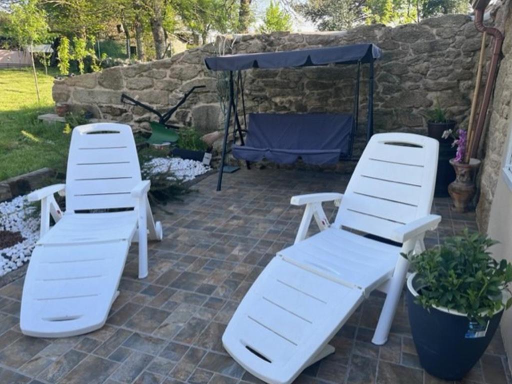 2 chaises longues blanches assises sur une terrasse dans l'établissement Carballo Alenza,2, à Castro Caldelas