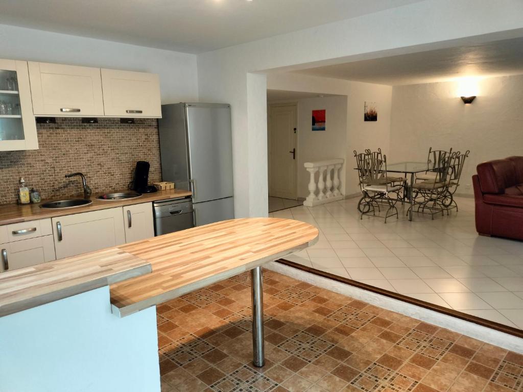 a kitchen and living room with a table and a couch at Location Rez de maison dans quartier charmant in Saint-Raphaël