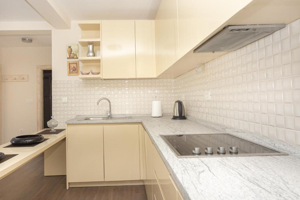 a kitchen with white cabinets and a sink at Apartments Horizont in Budva