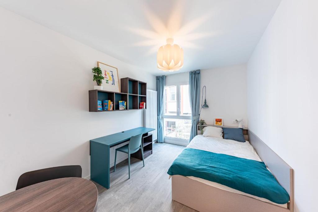 a bedroom with a blue bed and a desk at Cute Studio close to Paris - 1P - 501 in Ivry-sur-Seine