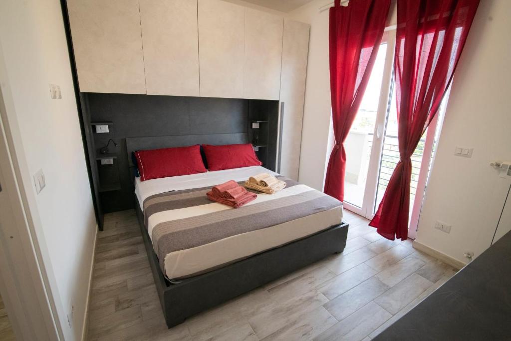 - une chambre avec un grand lit et des oreillers rouges dans l'établissement Casa Larry, à Marino